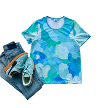 Blue and green camouflage t-shirt with jeans and sneakers on a white background