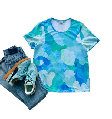 Blue and green camouflage t-shirt with jeans and sneakers on a white background